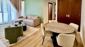 A modern living room with a sofa, coffee table, and dining table.