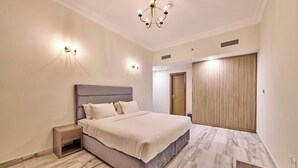 Ein Schlafzimmer mit Bett, Nachttischen, einem Kleiderschrank und einer Chandelier.