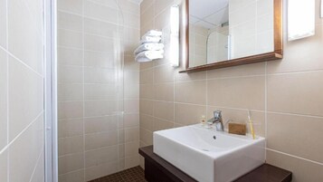 A bathroom with a white sink, a mirror, and a towel rack.