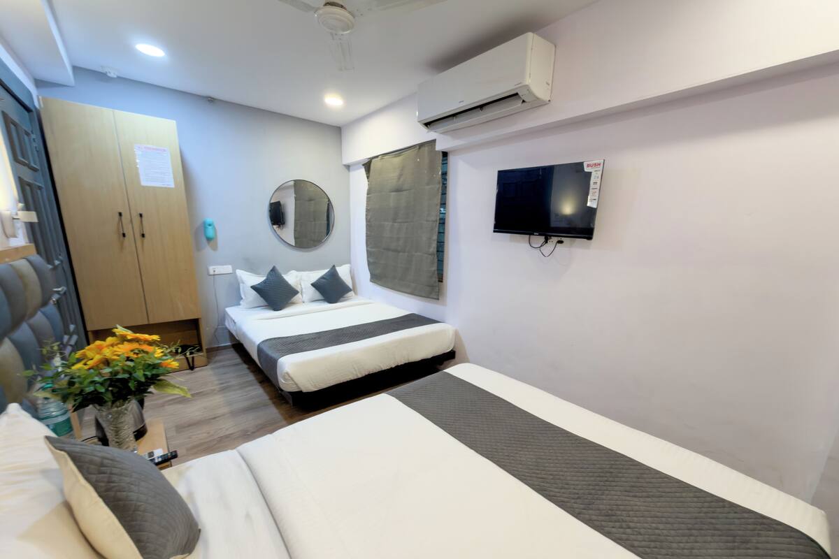 Ein Hotelzimmer mit einem Bett, einem Fernseher, einem Spiegel und einem Kleiderschrank.