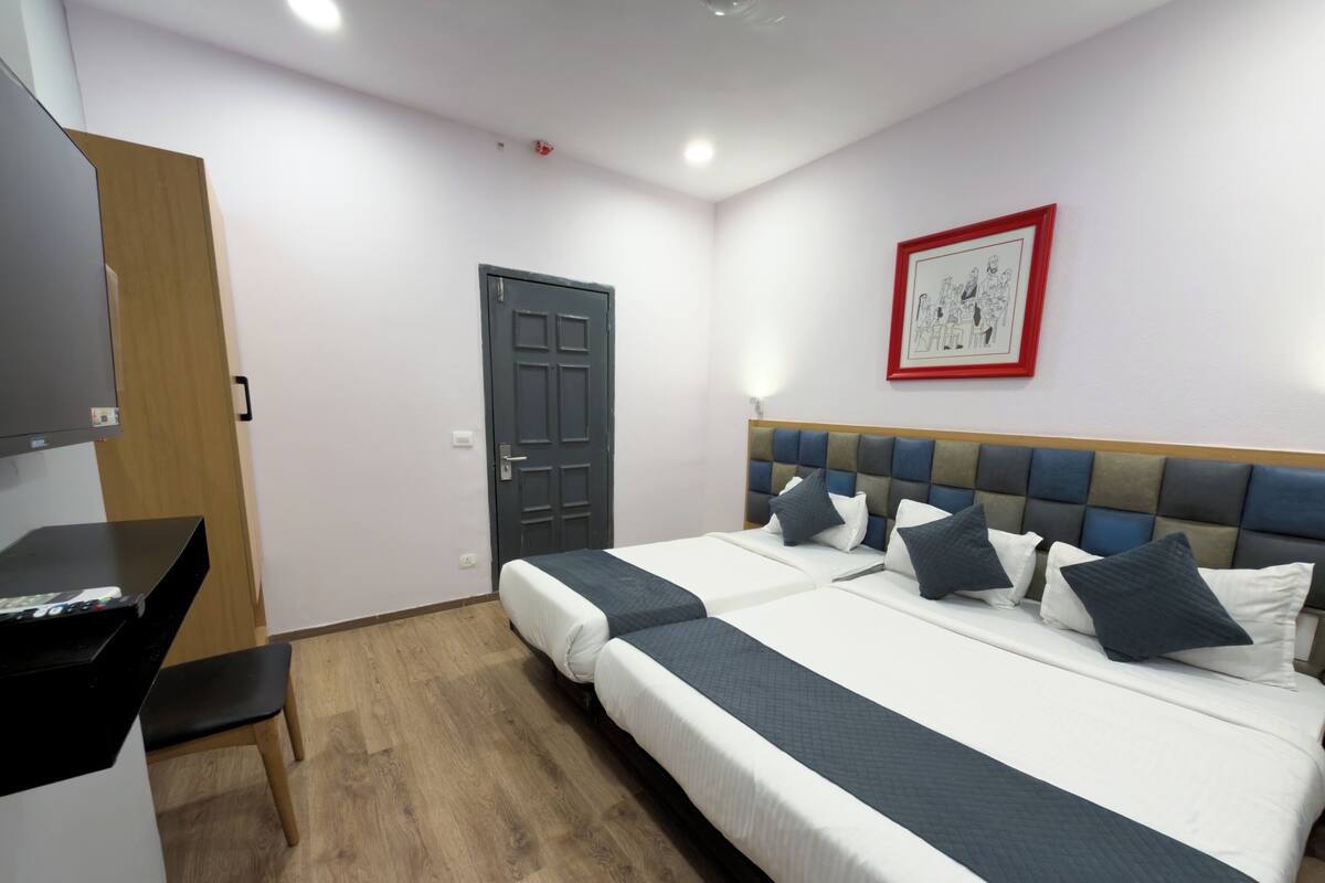 Ein Hotelzimmer mit einem großen Bett, einem Schreibtisch, einem Fernseher und einer Tür.