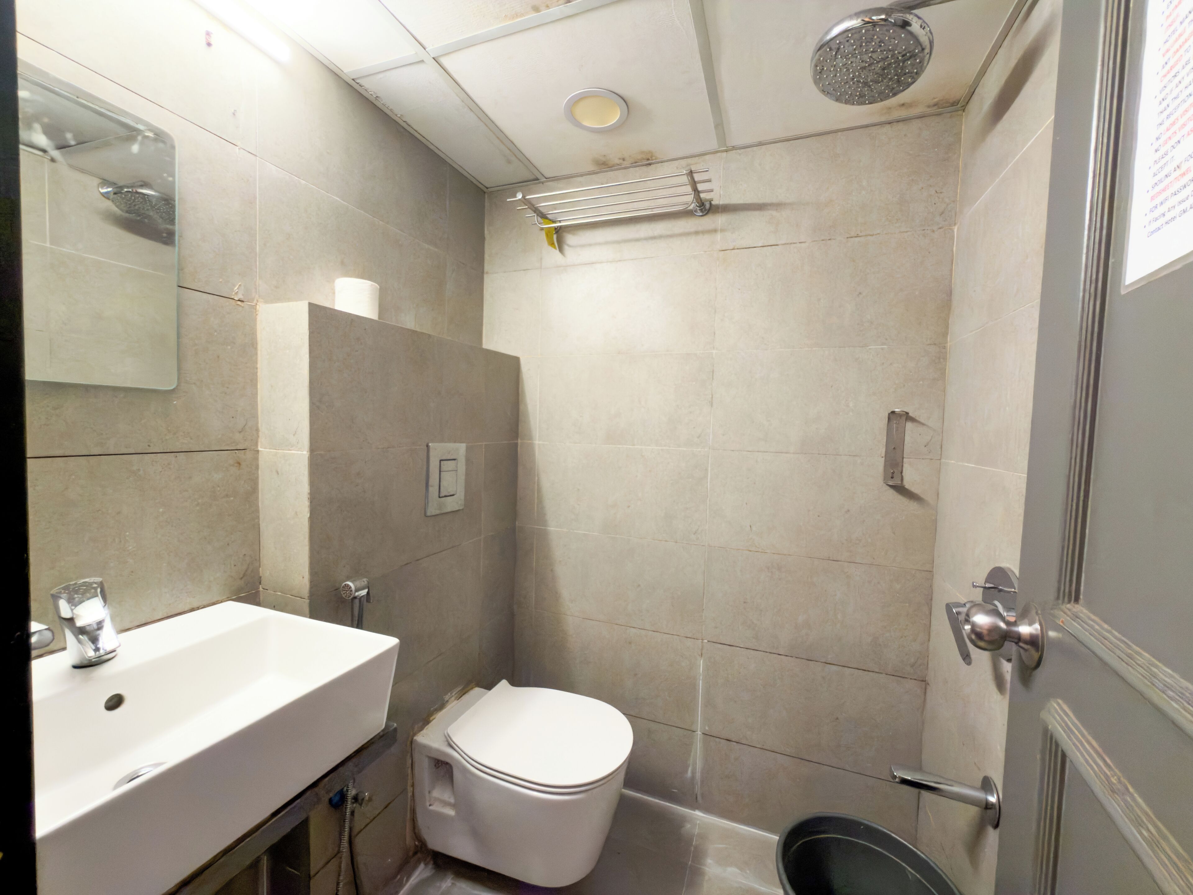 A bathroom with a sink, toilet, shower, and a mirror.