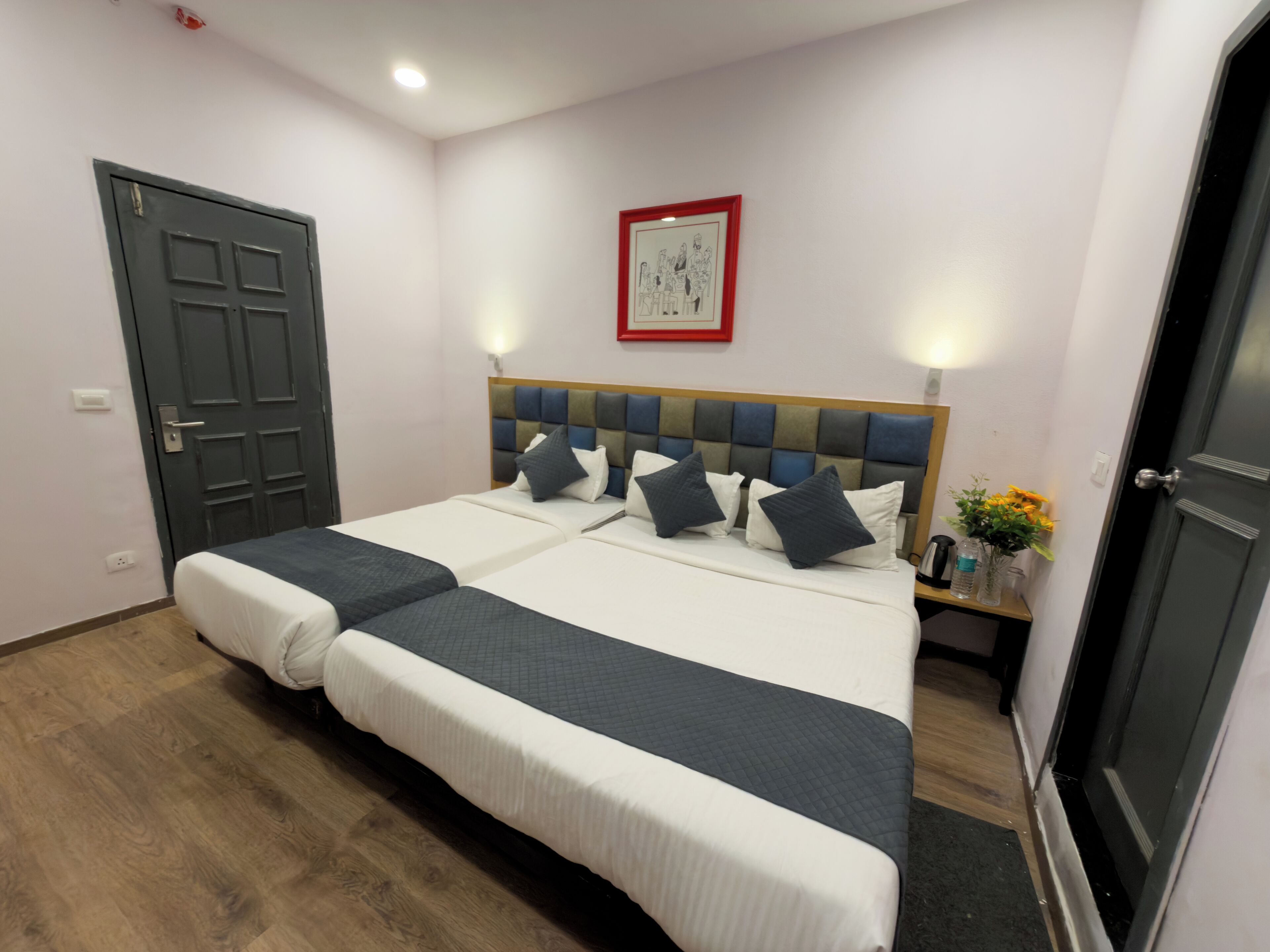 A double bed with a headboard, two bedside tables, and a wall-mounted picture.