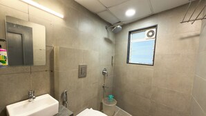 Ein modernes Badezimmer mit Waschbecken, Toilette, Dusche und einem Fenster mit Blick.