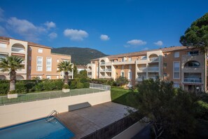 A hotel with multiple balconies, a swimming pool, and a mountainous backdrop. - Apartment 'Chez Mcvv' with Mountain View, Wi-Fi and Air Conditioning (Cavalaire-sur-Mer)