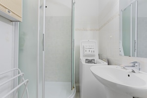 A bathroom with a shower, a sink, and a mirror. - Apartment 'Chez Mcvv' with Mountain View, Wi-Fi and Air Conditioning (Cavalaire-sur-Mer)