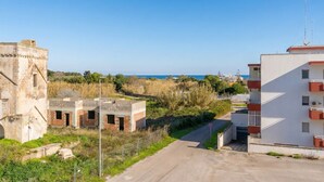 A coastal area with a mix of modern and historical buildings, a clear road, and a view of the sea. - Circe Sea View Apartment Otranto – Charming Studio with Terrace, Wi-Fi & AC (Otranto)