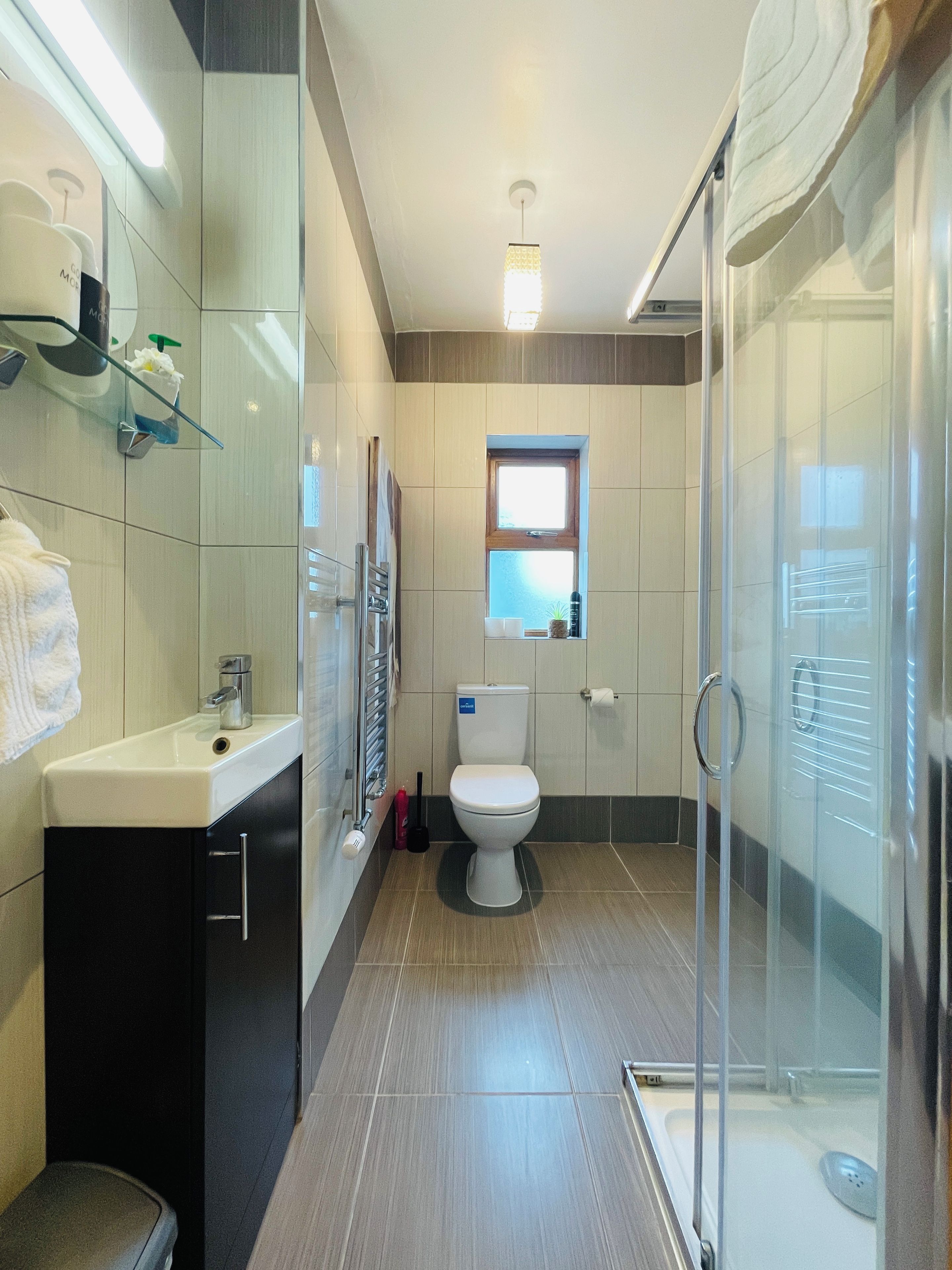Une salle de bain moderne avec une douche à parois de verre, des toilettes et un lavabo avec un miroir.
