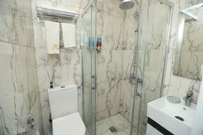 Habitación triple familiar, vistas a la ciudad | Baño | Jabón, champú y papel higiénico