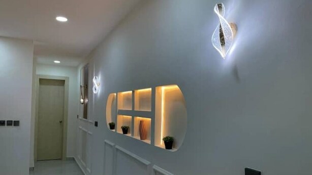 A hallway with recessed lighting and a wall-mounted light fixture. - Stylish 2-Bed Luxury Apartment in Ikeja GRA – 24/7 Power & Comfort (Lagos)