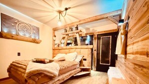 Una camera accogliente con un letto, una panca in legno e uno specchio.