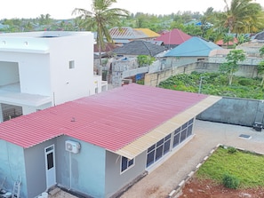 A residential building with a red roof, a small attached structure with a white facade, and a garden area. - Serene Beachfront Bungalow Escape in Uroa, Zanzibar (Uroa)