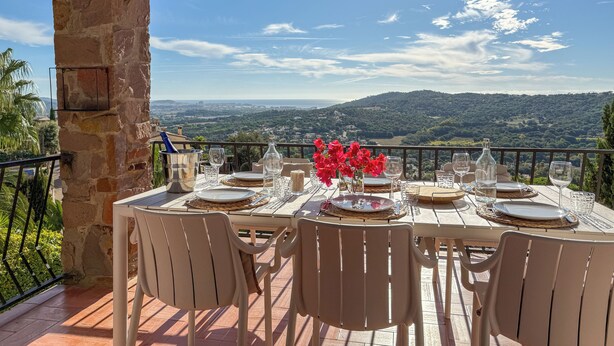 A table set for dining with a view of a mountainous landscape.