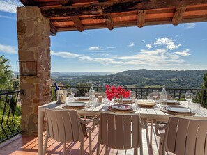 A table set for dining with a view of a mountainous landscape.