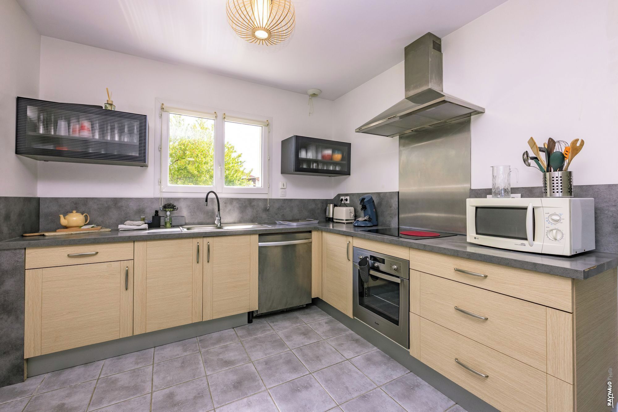 A modern kitchen with a stainless steel range hood, a microwave, and a dishwasher.