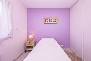 A bedroom with a bed, a nightstand with a lamp, a wall-mounted picture, and a window with curtains. - Maison Le Verdier - A Charming Getaway (Montans)