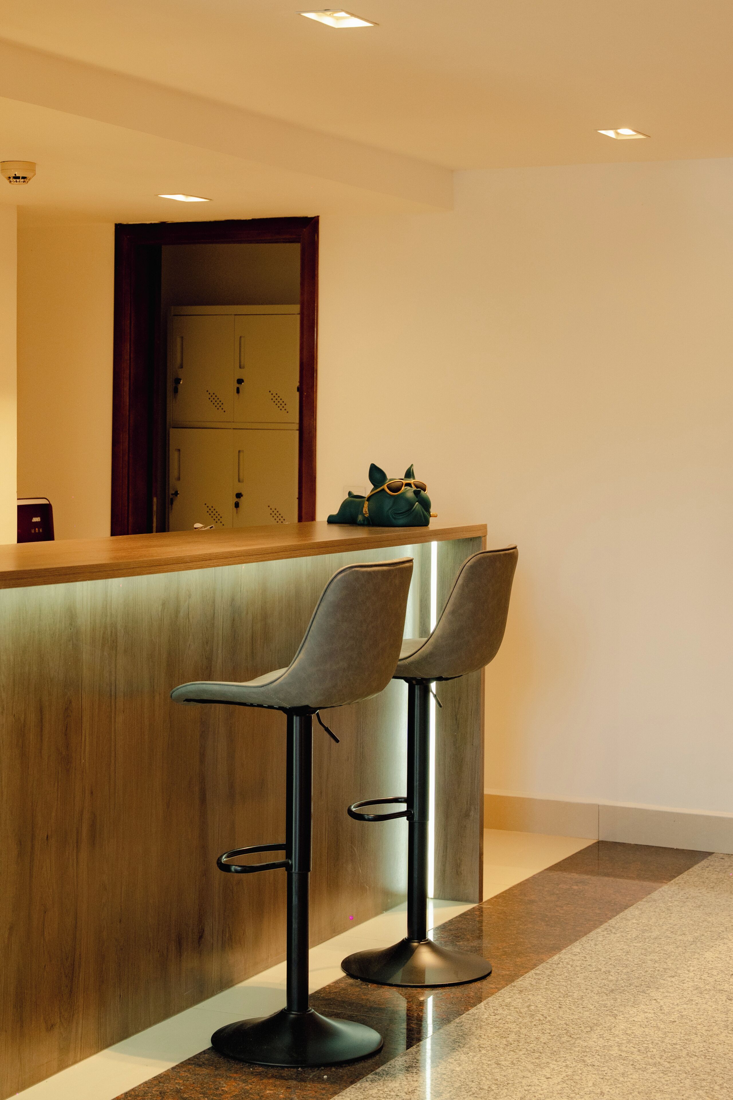 A bar area with two stools and a wooden counter.