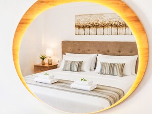 A hotel room with a large bed, a nightstand, a lamp, and a wall-mounted artwork. - Georgioupolis Blaue Villa Privater Pool by Interhome (Georgioupoli)