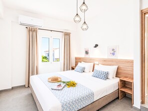 Un dormitorio moderno con una cama, cortinas, un ventanal y un aire acondicionado de pared.