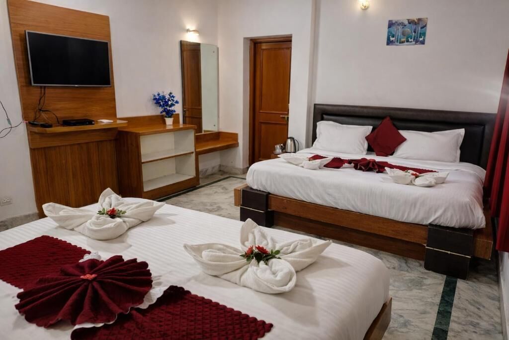 Una habitación de hotel con cama, televisión, escritorio y espejo.