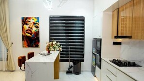 Una cocina moderna con encimera de mármol, persianas negras y armarios de madera.