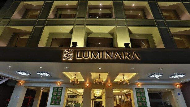 L'ingresso di un hotel dal design moderno, con un cartello ben visibile che riporta la scritta "LUMINARA".