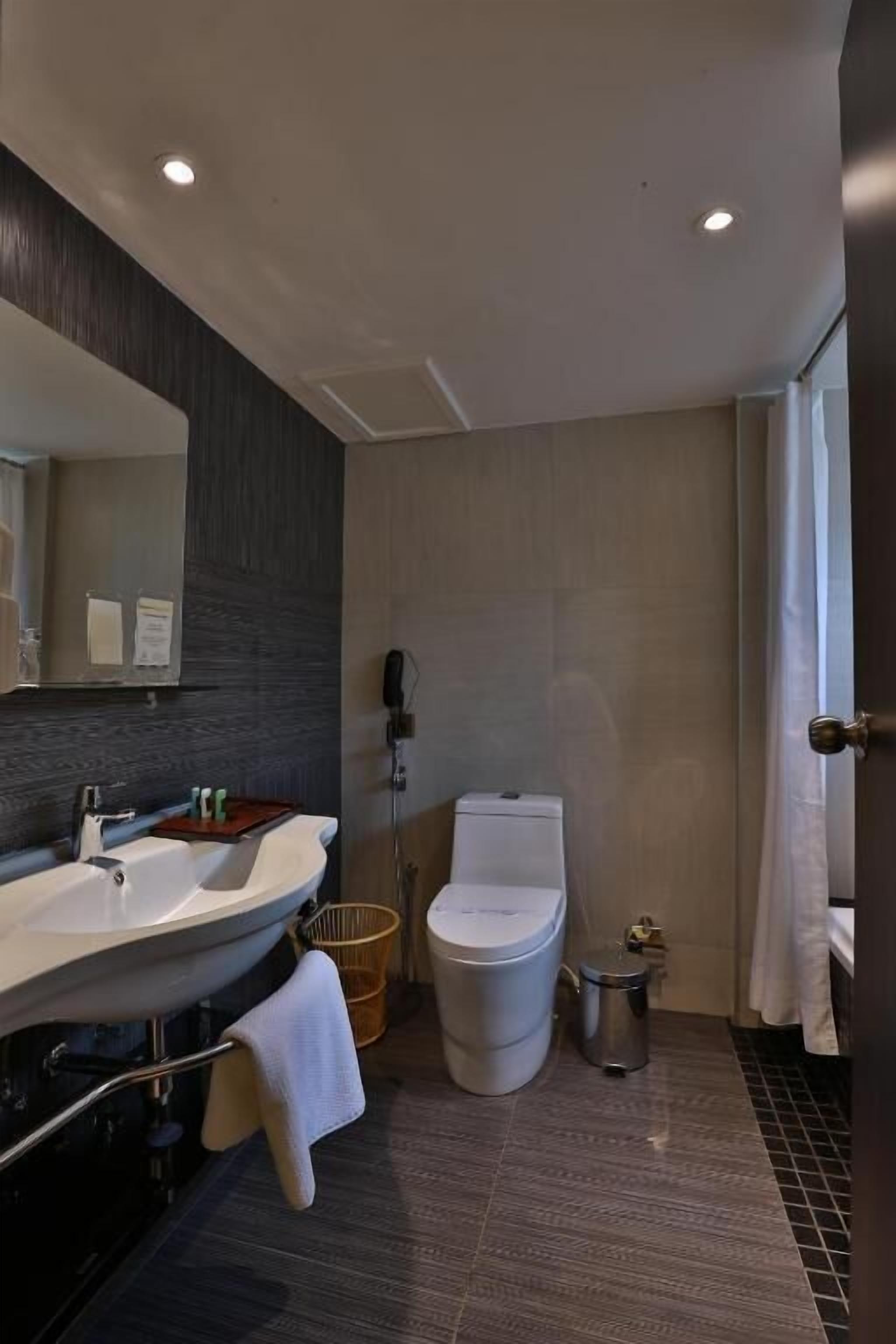 Un baño moderno con tocador de doble lavabo, inodoro y zona de ducha.