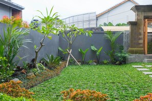 Un jardin bien entretenu, avec une variété de plantes et une pelouse soigneusement taillée.