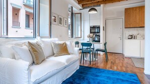 A modern living room with a white sofa, a blue rug, and a wooden ceiling. - Easylife - Milano - Mora 2 - Ticinese  (Milano)