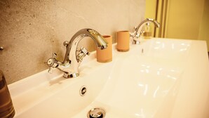 A bathroom with a large white sink, two chrome faucets, and a beige wall. - Château de la Grange Moreau - Pierre Moreau room (Vallon-sur-Gée)