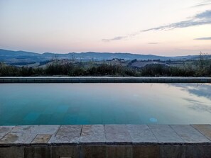 A swimming pool with a view of distant hills.