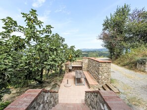 A stone pathway leading to a stone bench with a view of a mountainous landscape.