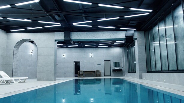 An indoor swimming pool with clear water, modern lighting, and a clean, minimalist design. - Shedevr plaza (Namangan)