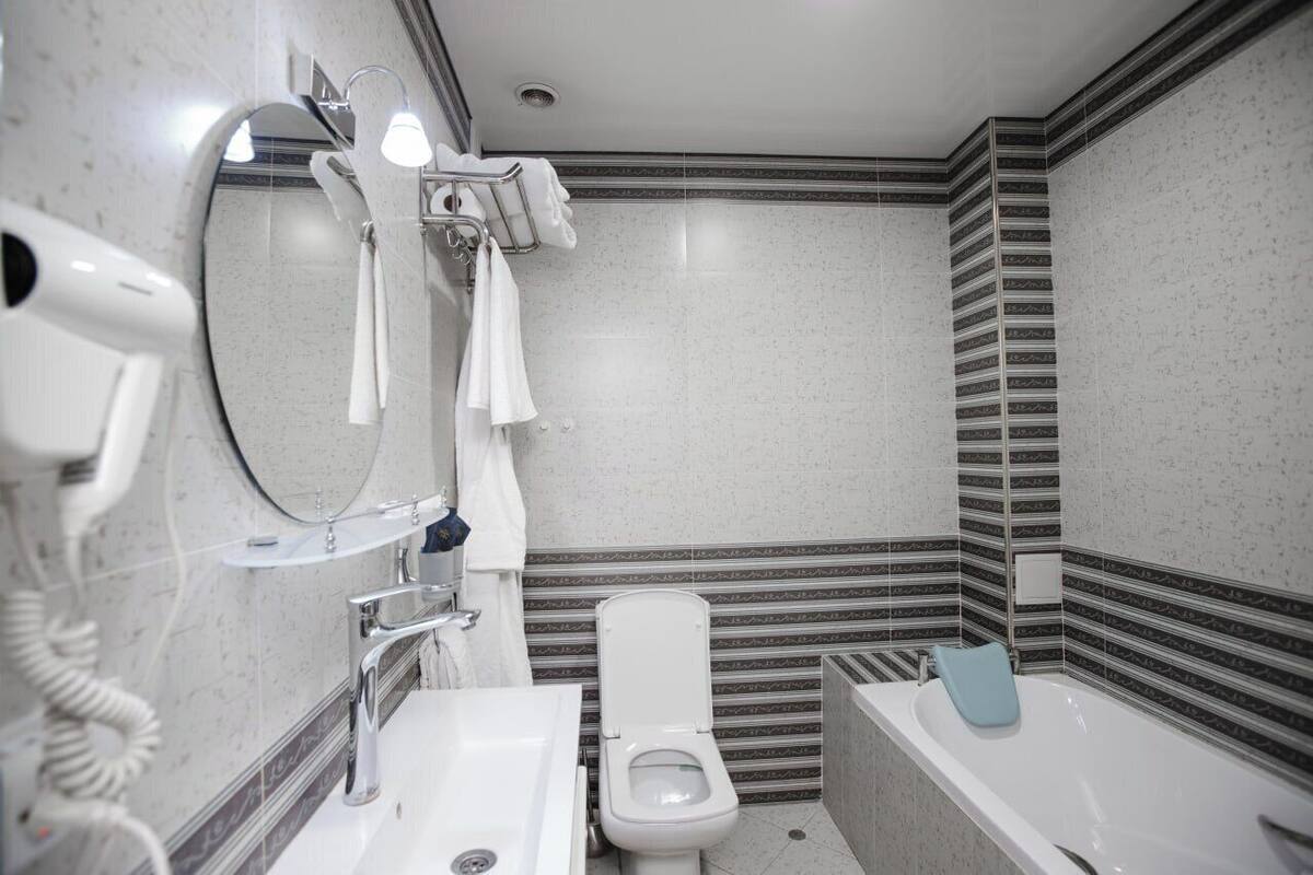 Ein modernes Badezimmer mit Toilette, Waschbecken und Badewanne.