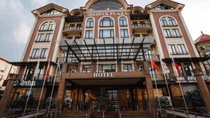A hotel with a prominent entrance, multiple floors, and a large arched window at the top. - Shedevr plaza (Namangan)