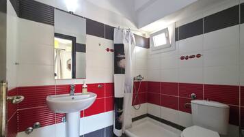 Een douche, handdoeken, zeep, toiletpapier