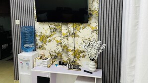 A modern living room with a mounted TV, a water dispenser, a small fridge, and a console table with decorative items. - ✨ Elegant 1-Bedroom  – Comfort, Class & Peace ✨

📍 Located along TRM Drive (Nairobi)