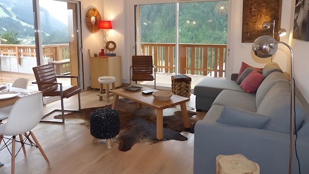 A modern living room with a sofa, chairs, a coffee table, and a view of the outdoors. - Apartment "Les Loges Blanches 101" with Wi-Fi (Châtel)