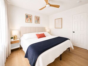 A bedroom with a bed, nightstands, a ceiling fan, and artwork on the walls. - Augustine · 10 min to NRG and the Medical Center · 2 baths (Houston)
