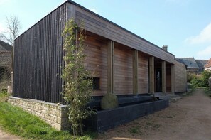 Ein modernes Gebäude mit Holzfassade und einer schwarzen, vertikalen Platte.