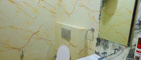 A bathroom with a toilet, sink, and shower.