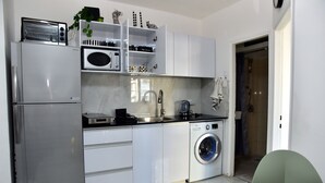 A modern kitchen with a built-in microwave, toaster, and washing machine. - 2-bedroom Luxury apartment On The Sea Bat Yam (Bat Yam)