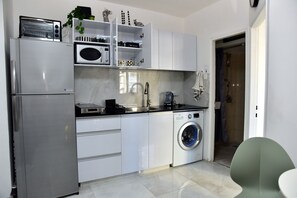 A modern kitchen with a built-in microwave, toaster, and washing machine. - 2-bedroom Luxury apartment On The Sea Bat Yam (Bat Yam)