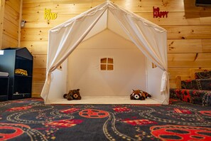 A tent-like structure with a small window, two teddy bears inside, and a patterned carpet. - Majestic Horizon by Ghosal Luxury Lodging (Sevierville)