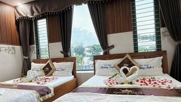 Una camera d'albergo con due letti, ognuno decorato con un cuore e un cigno.