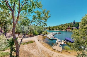 A lakeside view with a dock, boats, and a clear sky. - Lake Arrowhead Waterfront Retreat | Game Room (Lake Arrowhead)