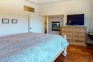 A bedroom with a bed, dresser, TV, and fireplace. - Lake Arrowhead Waterfront Retreat | Game Room (Lake Arrowhead)