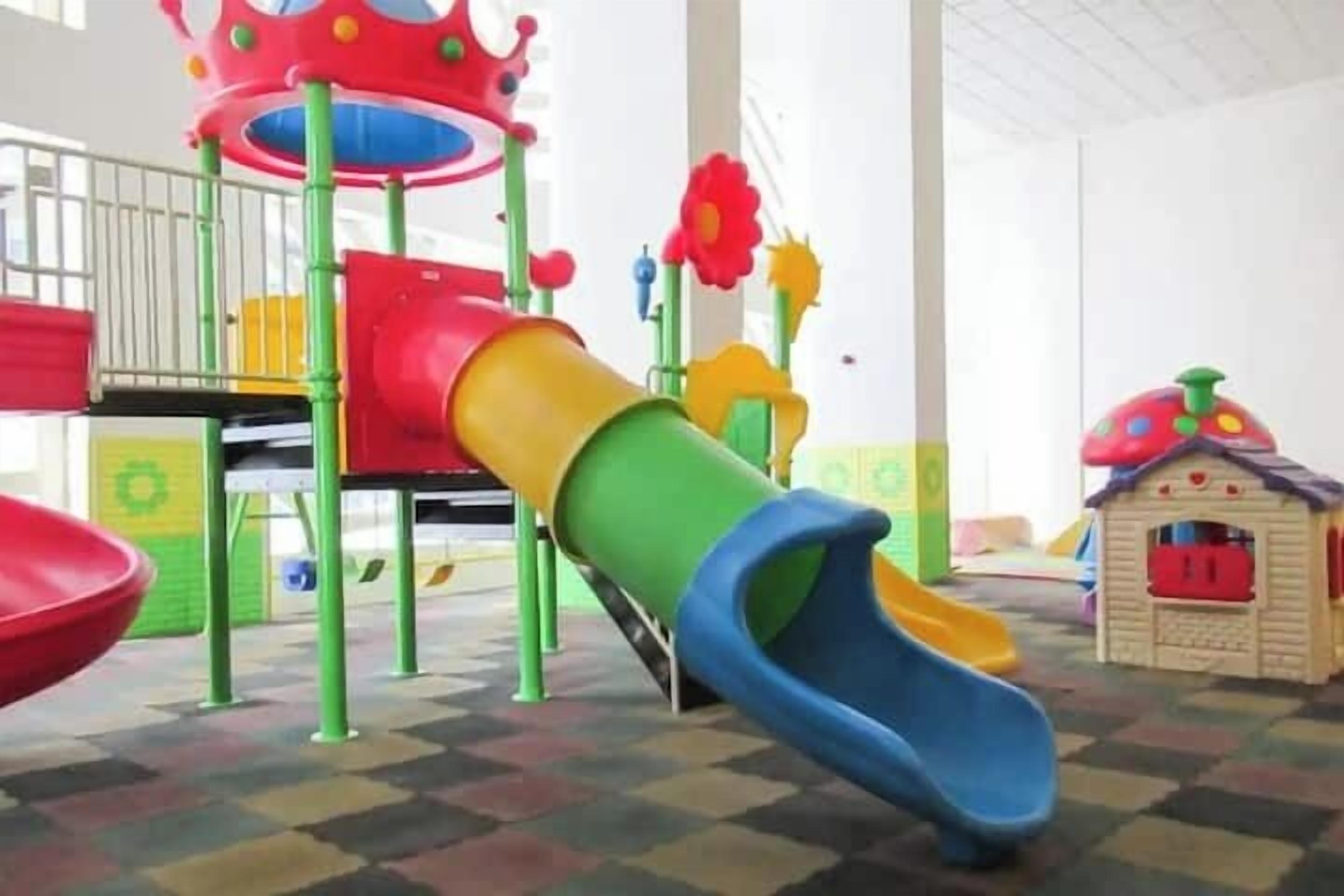 A children's play area with a slide, a small house, and a crown-shaped structure.