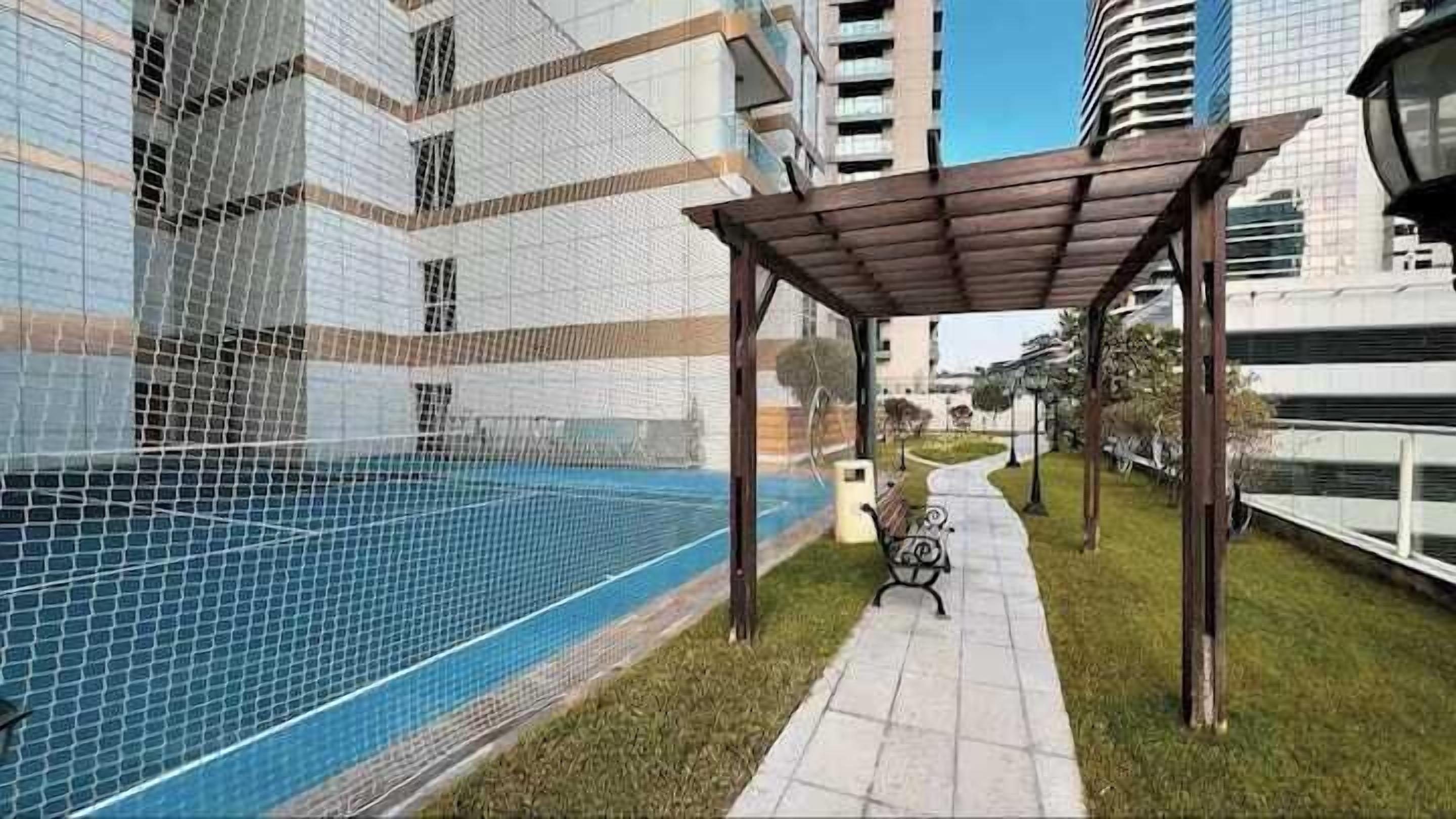 Zona residencial con piscina, terraza techada y un camino.