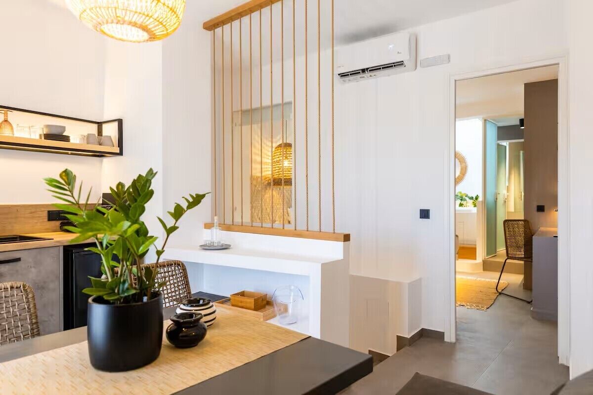 Una cocina moderna con encimera de madera, una planta en maceta y una lámpara colgante.
